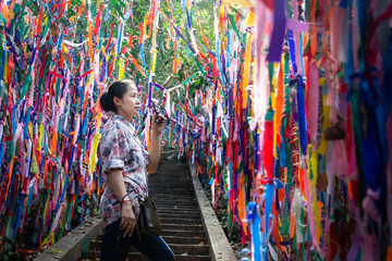 Obraz premium A young woman standing between colorful fabric ribbons. Background for tourist attractions, religious sites, holy places 