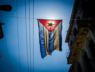 Cuban flag hangs in a street of the working-class neighborhood of Central Havana