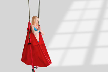 Fly yoga. Girl standing in a red hammock for aerial yoga