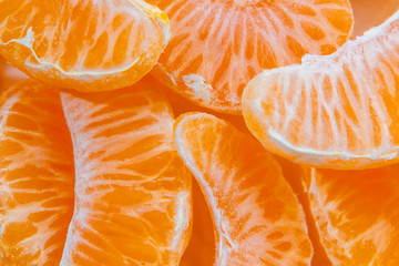 Several peeled ripe Mandarin slices, texture background