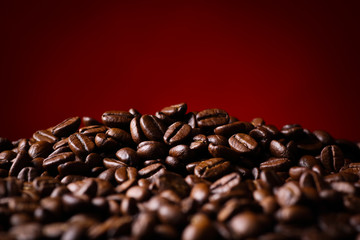 Obraz premium 赤背景にコーヒー豆のアップ