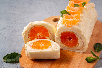 Sweet cake roll with whipped cream and tangerine filling