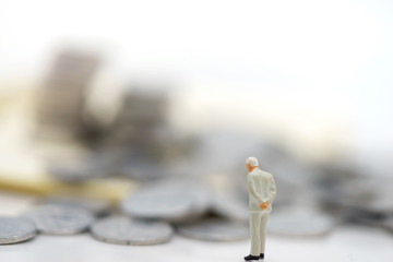 Miniature people:  Businessmen standing with coins stack, Finance, investment and growth in business concept.