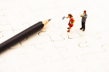 Miniature people: Business team reading book with pencil, education and business concept.