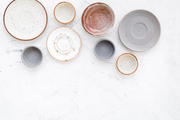 Ceramic tableware pattern. Empty plates and mugs on white background top view copy space