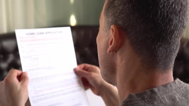 Adult Man Is Applying For A Home Loan. Credit application form on a paper sheet
