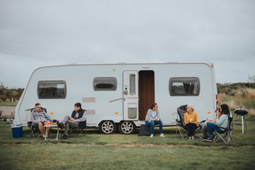 Group of people sitting outside a trailer