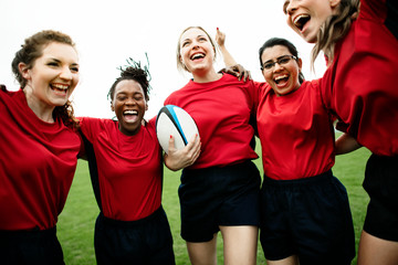 Energetic female rugby players celebrating