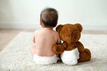 Back of a baby with a teddy bear - obrazy, fototapety, plakaty