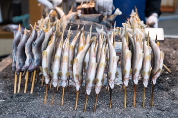 Fish Ayu with salt being charcoal broiled in Japanese grilled fish style , Ayu  is famous fish and traditional Japanese cooking style ,Many Ayu fish surrounding  of charcoal broiled in Japan.