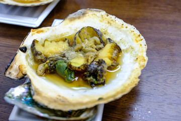 Abalone sea food, fresh abalone cut into small pieces in the shell at fish market in Japan