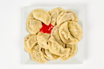 Dumplings on a white plate with ketchup