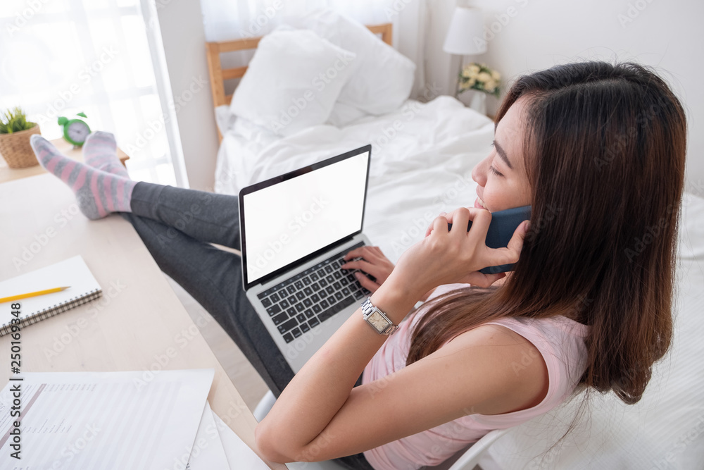 Poster top view of woman use laptop and talk on mobile with leg on table chill out working at home.mock up template device screen.Digital lifestyle concept.clipping path screen.