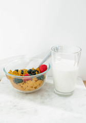 Granola, cereal with berries and a glass of milk