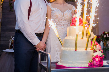 Fototapeta premium fireworks in a wedding cake on the background of the newlyweds