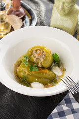 Homemade Meat and Rice Stuffed Bell Peppers with broth served for lunch on the table