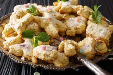 Mexican hojarascas curly festive cookies with pecans closeup on a dish. horizontal