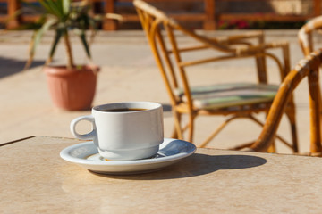 Cup of coffee on a table in cozy outdoor cafe