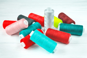 Many colorful threads lying on white table