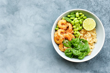 Poke bowl with prawn, edamame bean, spinach and rice. Top view, gray background