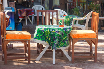 Fototapeta na wymiar Empty table and chairs in cozy outdoor cafe in Luxor, Egypt