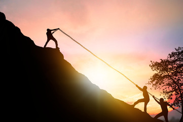 silhouette of success, business teamwork and motivation concept, people pull friends and help hiking  on mountain
