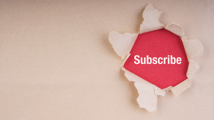 SUBSCRIBE text on brown envelope and torn paper. Concept Image