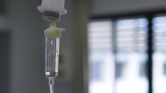 Dripping of set iv fluid intravenous drop saline solution in hospital room.