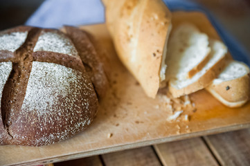 Sliced baguette and round rye black bread. Sandwich with bread, butter and dill. White loaf and rye bread close up and copy space