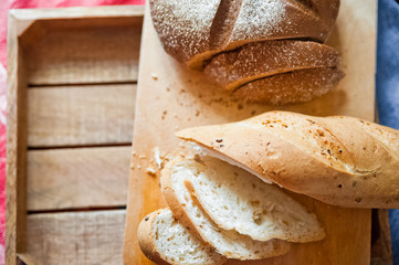 Sliced baguette and round rye black bread. Sandwich with bread, butter and dill. White loaf and rye bread close up and copy space