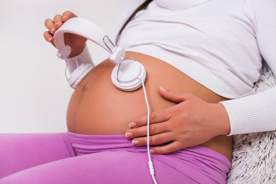 Pregnant woman playing music to her baby.