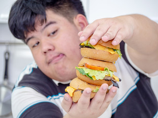Diet failure of fat man eating fast food unhealthy hamberger.