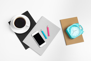 Smartphone and coffee cup, notepad close up top view