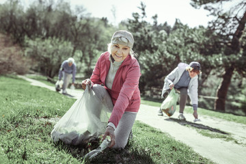 Smiling woman in age taking plastic bottle