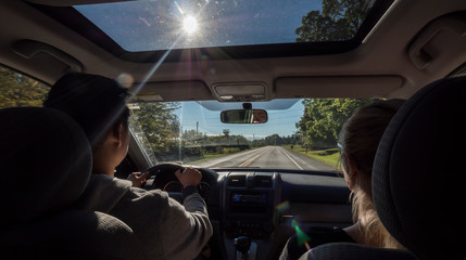 Young couple traveling in a car in the US suburbs