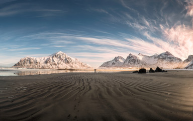 Fototapeta na wymiar Panorama of Snow mountain range with sand furrows on coastline at Skagsanden beach