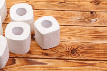 Toilet paper rolls on wooden background top view