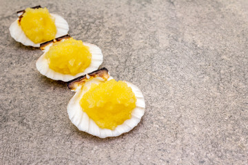 Capelin roe in seashells. Lightly salted caviar snack on a stone background