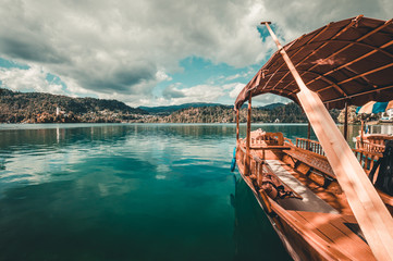 Traditional wooden boats Pletna on the backgorund of Church on the Island on Lake Bled, Slovenia. Europe.