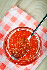 Red caviar in glass jar with spoon . Sea food. Healthy eating. Diet. Wooden background in the style of Shabby Chic.
