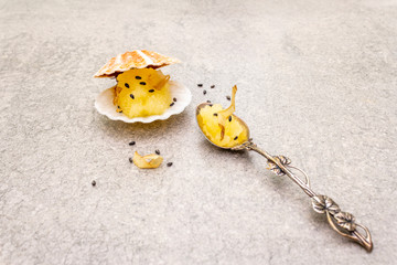 Obraz premium Capelin roe in seashells. Black sesame seeds with bonito flakes. Lightly salted caviar snack in silver spoon on a stone background