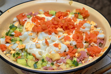 Sliced vegetables and boiled eggs in a yellow bowl, preparation for cooking salad