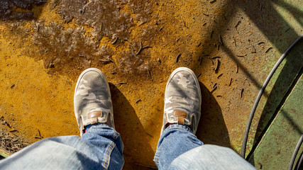male wear Green gumshoes or shoes on a rusty metal floor background. empty copy space for inscription. 