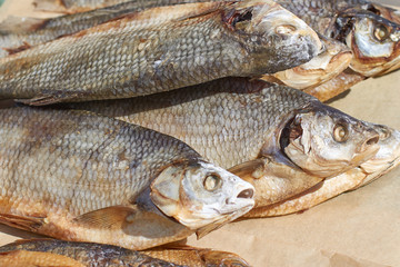 Dried fish with salted scales on packaging paper, close-up