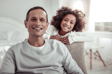 Obraz premium Joyful cheerful father and daughter looking at you very attentively