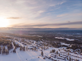 Panorama aerial view of Idre Fjäll cabins during sunrise a clear winter day in Sweden with one of the slopes in the photo. 