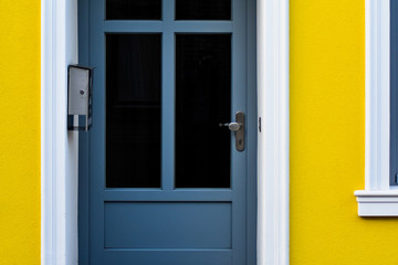 Blaue haustür in einem gelben haus