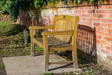 Fototapeta na wymiar Memorial bench in the sunny, but quiet, part of the church yard