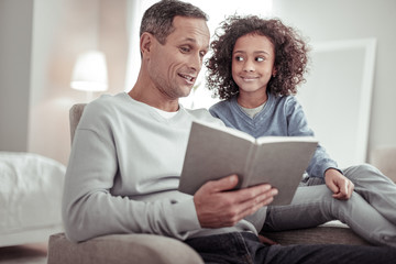 Careful father reading a story to a girl