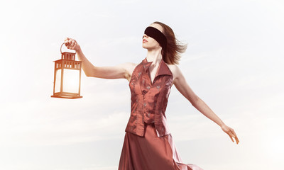 Attractive girl muse with old lantern in hand at summer day